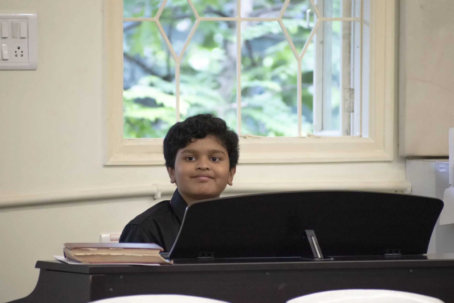 Piano student Arya performing on stage at KMC, Bangalore