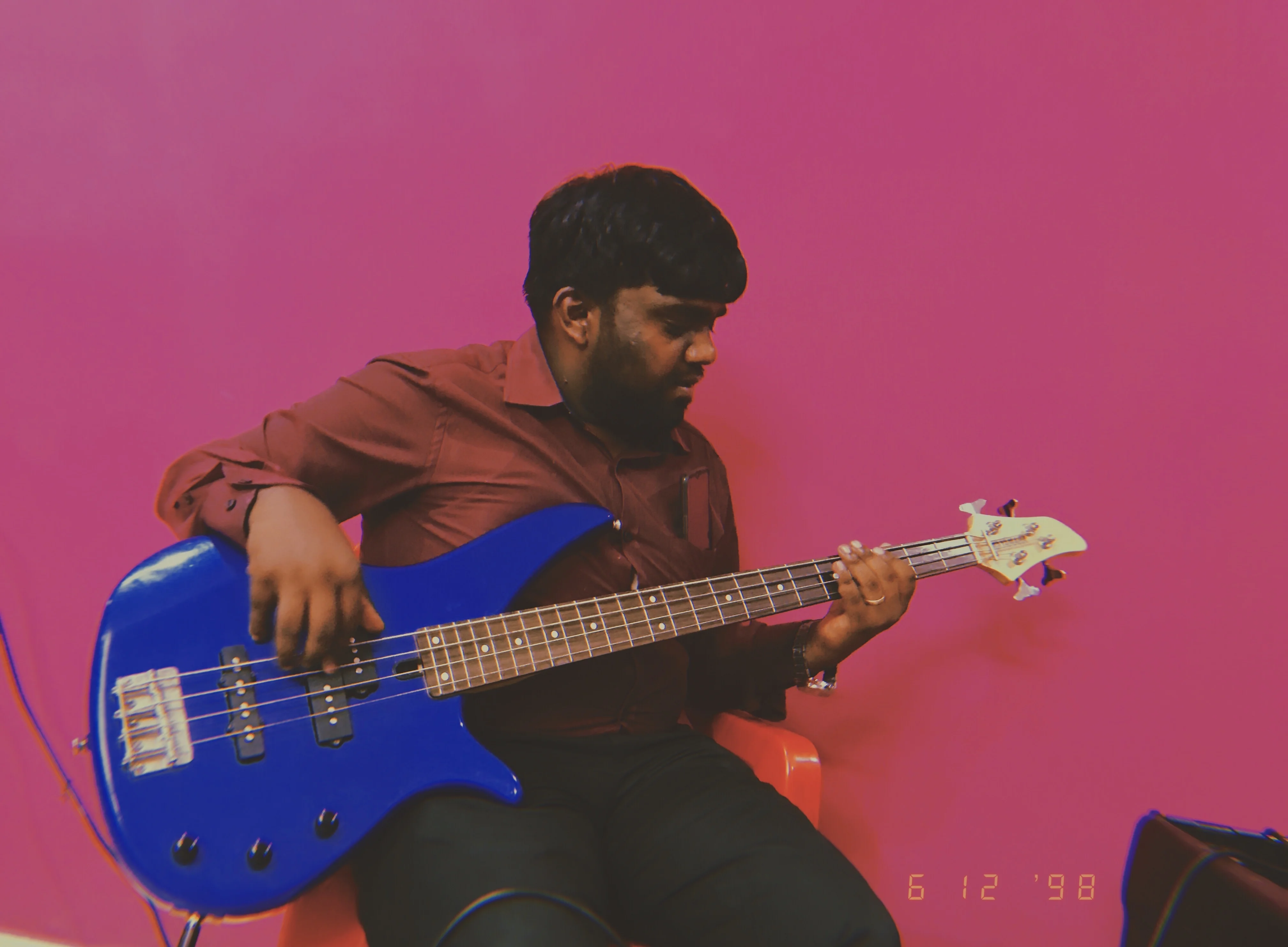 Bass guitar teacher playing electric bass at FSG rehearsal — blue bass guitar