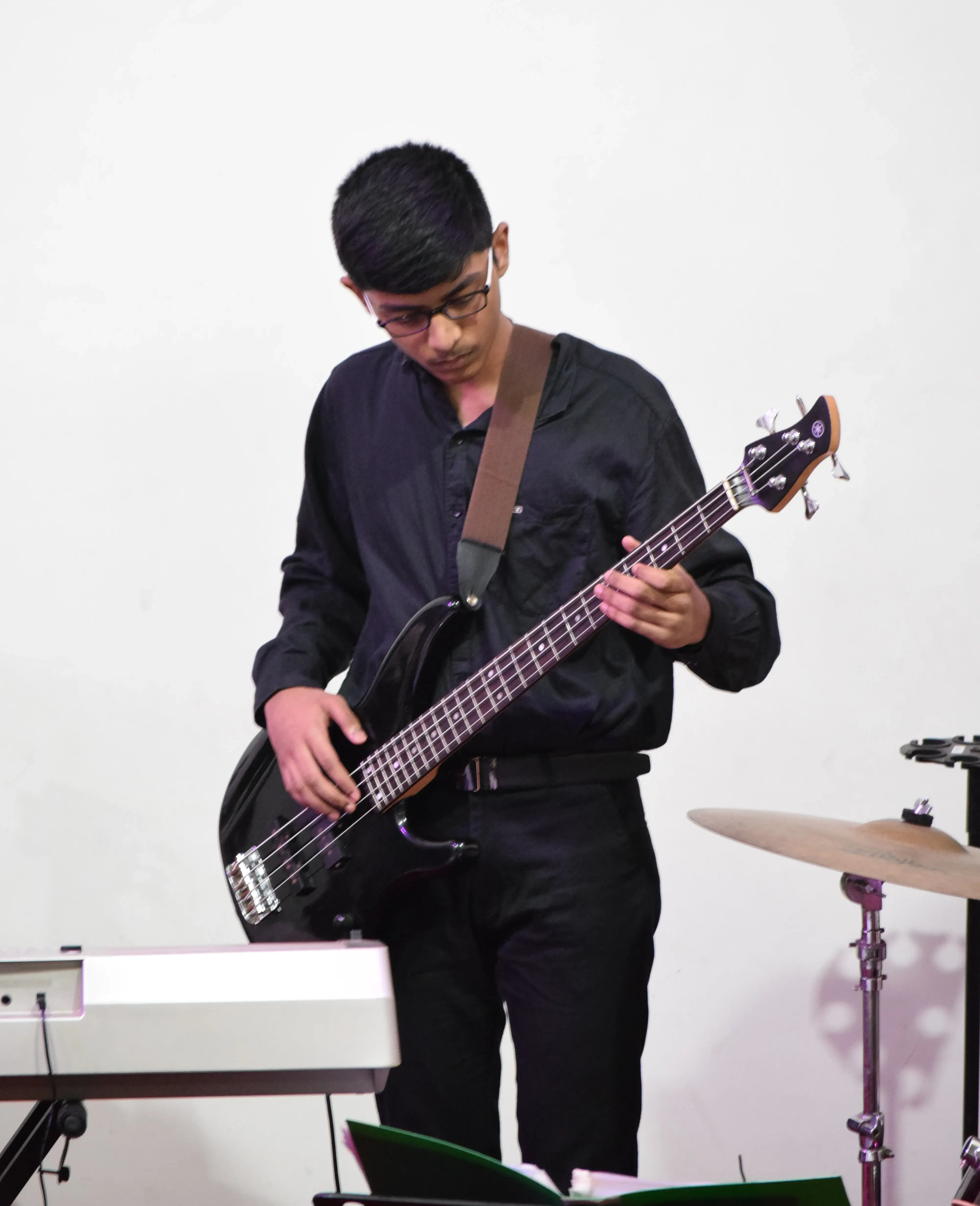 FSG bass guitar student Joshua performing on stage at Banaswadi Bible Church Christmas Concert 2021