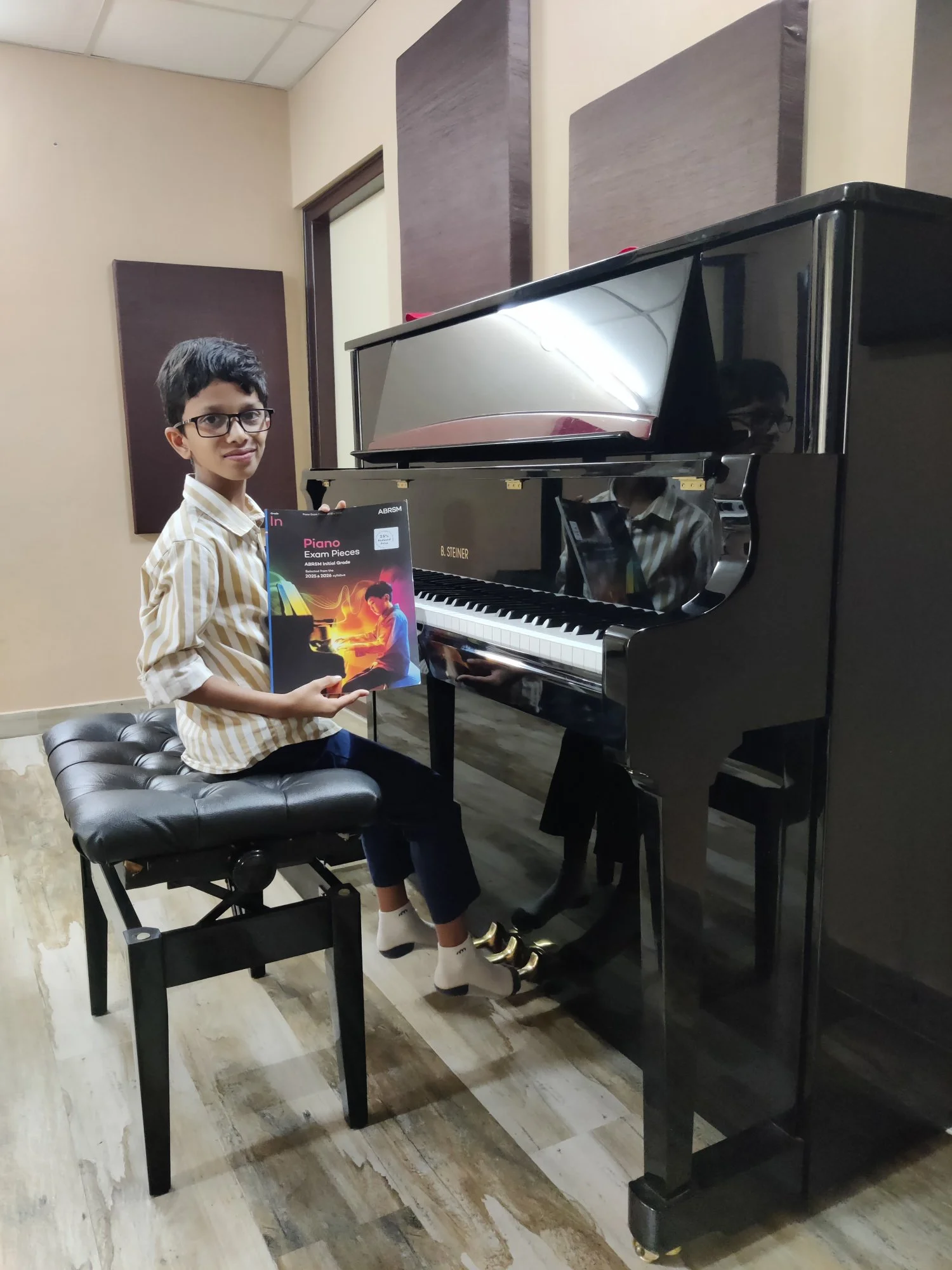 Piano student at the B. Steiner upright grand in Fingersmith's Garage exam room with ABRSM book